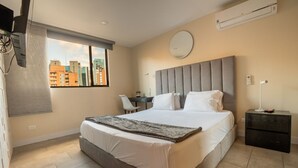 Un hotel moderno con una cama grande, un escritorio y vistas a la ciudad.