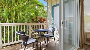 A balcony with wicker furniture and a view of lush greenery. - 2 Bedroom Condo in Poipu with Pool, Hot Tub, AC, Just steps to the Beach & Pools (Koloa)
