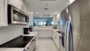 A modern kitchen with white cabinetry, stainless steel appliances, and a tiled backsplash.