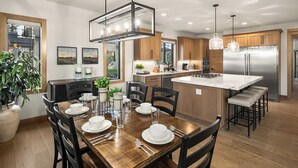 Una cocina moderna con armarios de madera, una isla central e iluminación colgante.