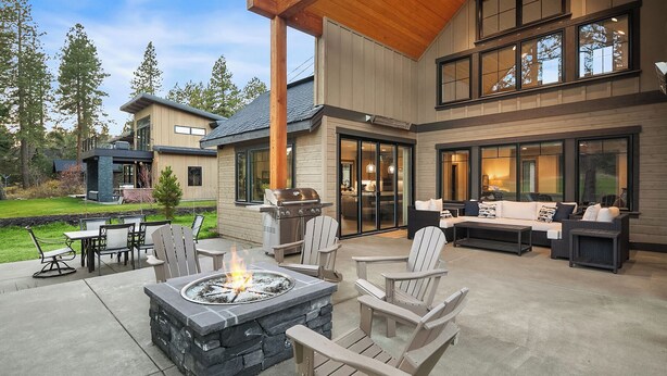 Un espacio al aire libre con mobiliario exterior, una chimenea y una parrilla.