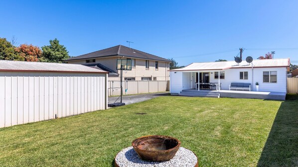 A residential backyard with a lawn, a barbecue grill, and a small shed. - High Tide - Pet Friendly with Fire Pit (Sanctuary Point)