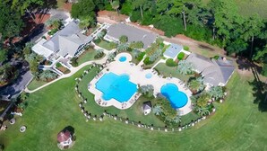 An aerial view of a residential property with a large swimming pool, multiple decks, and lush greenery. - JonBie Maisons SEA GLASS COTTAGE cart included with booking (Daufuskie Island)