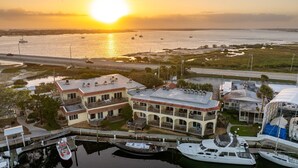 A waterfront property with multiple buildings, a marina with boats, and a sunset view. - Garden Studio | Sleeps 4 | Near Historic St. Augustine (St. Augustine)