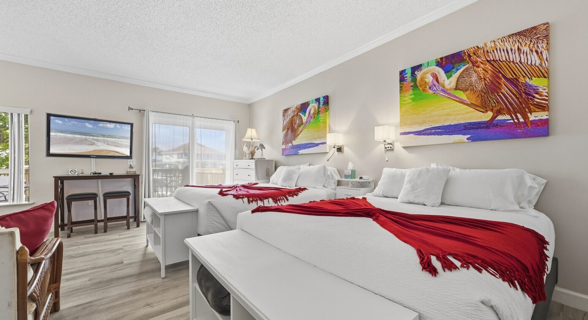 A hotel room with a large bed, a desk, a chair, and a TV.