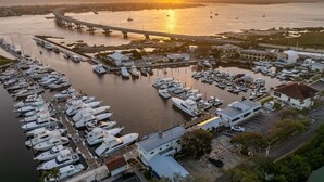 A marina with numerous boats docked, a bridge in the background, and buildings adjacent to the water. - Pet Friendly King Studio with Harbor Views (St. Augustine)