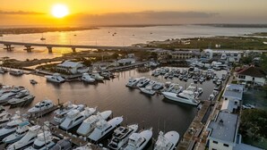 A marina with numerous boats docked, a bridge in the background, and buildings along the waterfront. - Harbor View Studio | King Bed + Covered Balcony | Dogs OK (St. Augustine)
