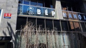 Un immeuble à plusieurs étages doté d’une architecture moderne, avec une enseigne bien visible portant le nom « BEP » et le mot « HANOÏ », indiquant son emplacement.