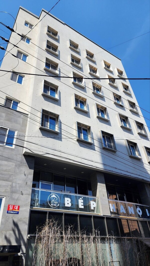 A multi-story building with a modern architectural design, featuring a prominent sign with the name "BEP" and the word "HANOI" indicating its location.