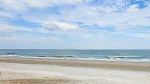 Enjoy a serene beach experience with calm waters and a wide sandy shore.