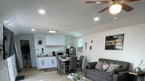 A modern apartment with a kitchen, dining area, and living room. - Cabin Experience near all (Wilkes-Barre)