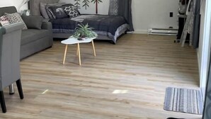 A modern living room with a grey sofa, a small coffee table, and a ceiling fan. - Cabin Experience near all (Wilkes-Barre)