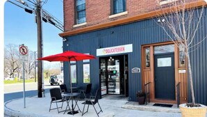 A building with a sign reading "DELICATESSEN" and outdoor seating with a red umbrella. - Cabin Experience near all (Wilkes-Barre)