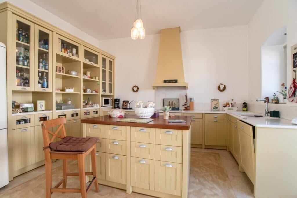 Una cocina con una isla central, armarios de madera y una lámpara colgante.