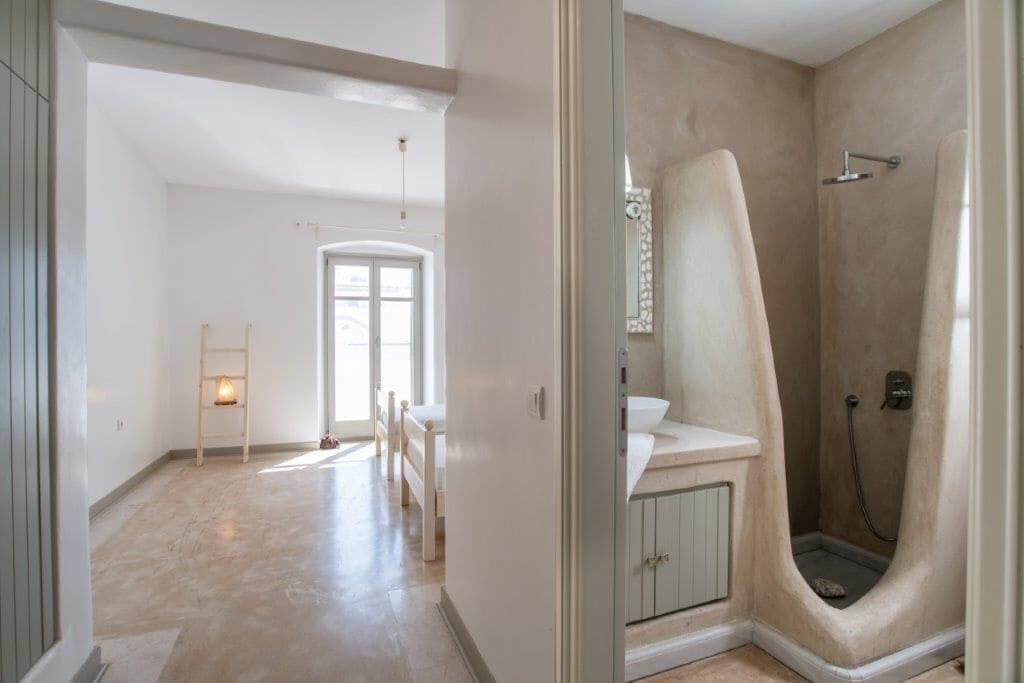 Un baño amplio con ducha, lavamanos e inodoro.