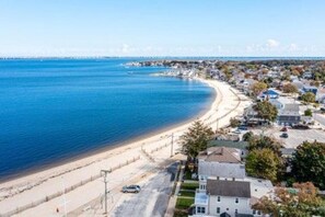 Zona residencial a la costa, amb una platja, cases i una vista despejada de l'oceà.