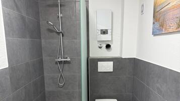 Un baño moderno con ducha, inodoro y bañera.