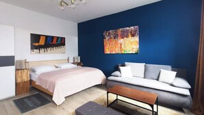 Een moderne hotelkamer met een bed, een bank en een klein tafeltje.