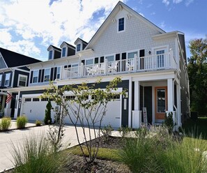 A two-story residential building with a balcony, a garage, and a front porch. - Bayside Resort * 1 Small Dog Allowed: Luxury 5BR B (Selbyville)