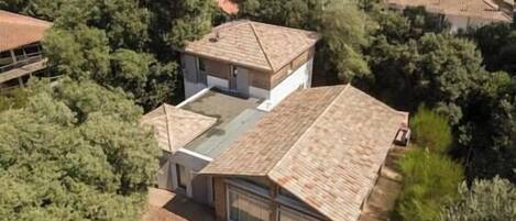 Una casa de dos pisos con un garaje amplio y un patio cubierto.