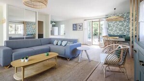 Een moderne woonkamer met een modulaire bank, een salontafel en een eethoek met stoelen.