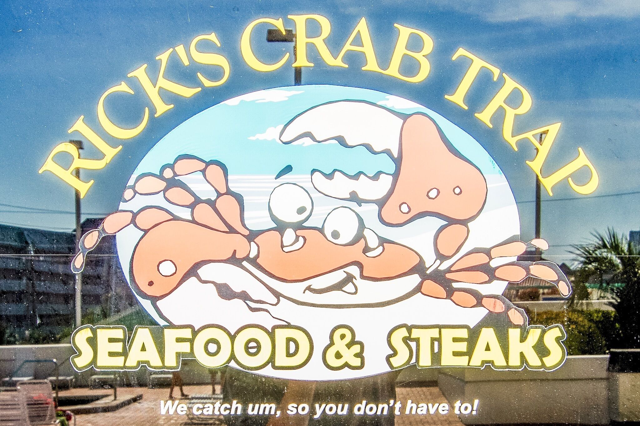 A sign for Rick's Crab Trap with a cartoon crab and the text "SEAFOOD & STEAKS".