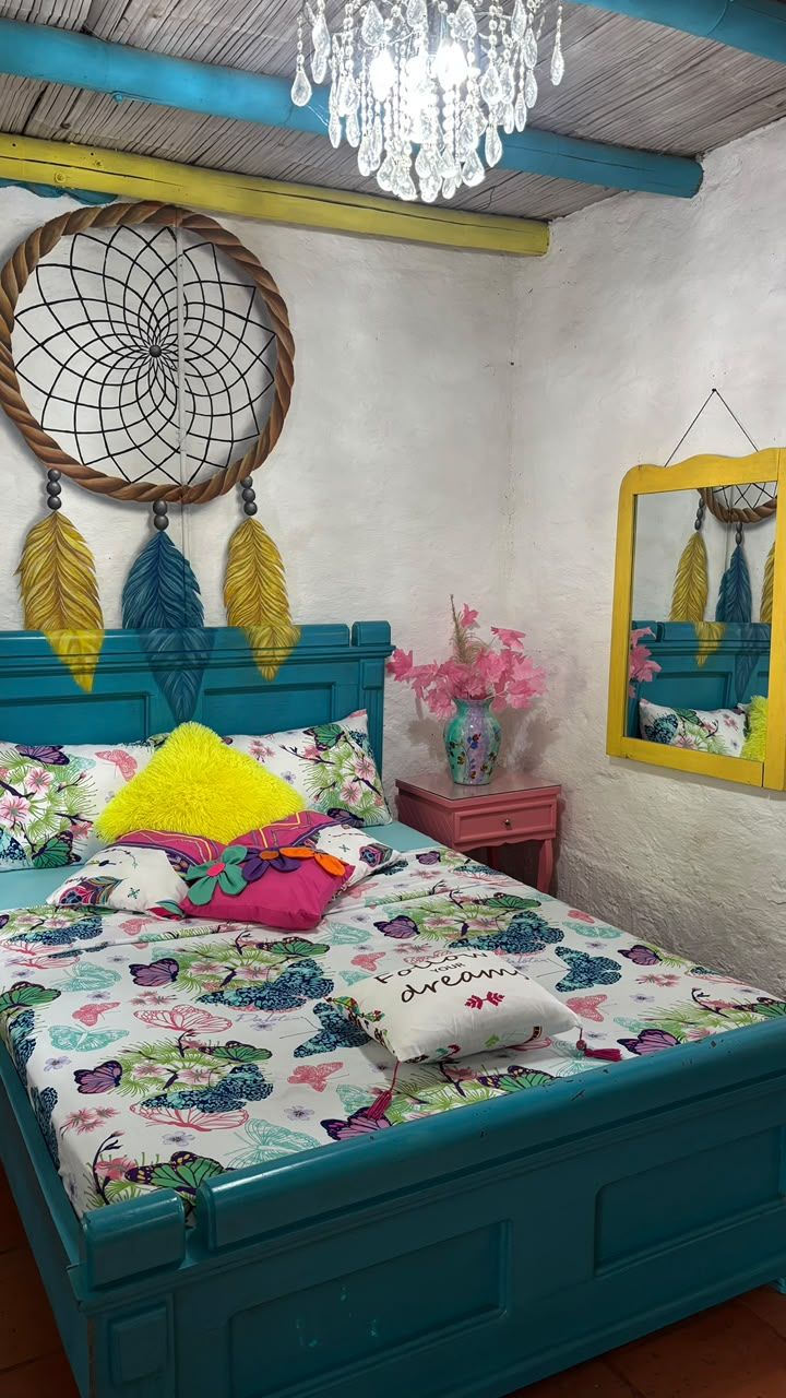 A bedroom with a bed, a bedside table, a mirror, and a wall decoration.