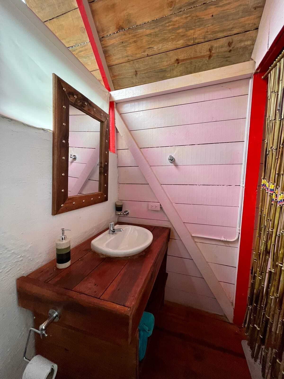 Une salle de bain avec un meuble-lavabo en bois, un évier, un miroir et des toilettes.
