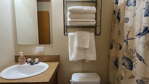 A bathroom with a sink, mirror, towel rack, and toilet.
