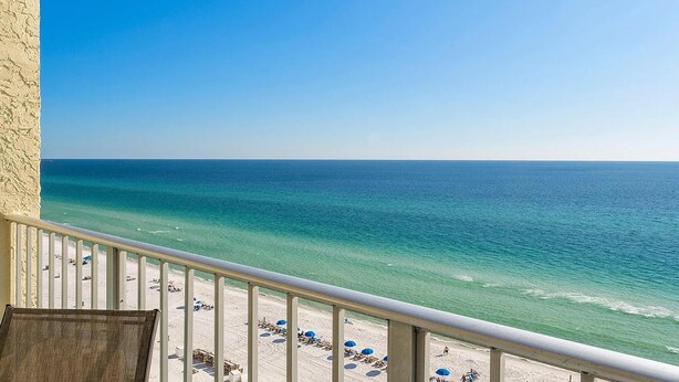 A balcony with a view of a beach and ocean.