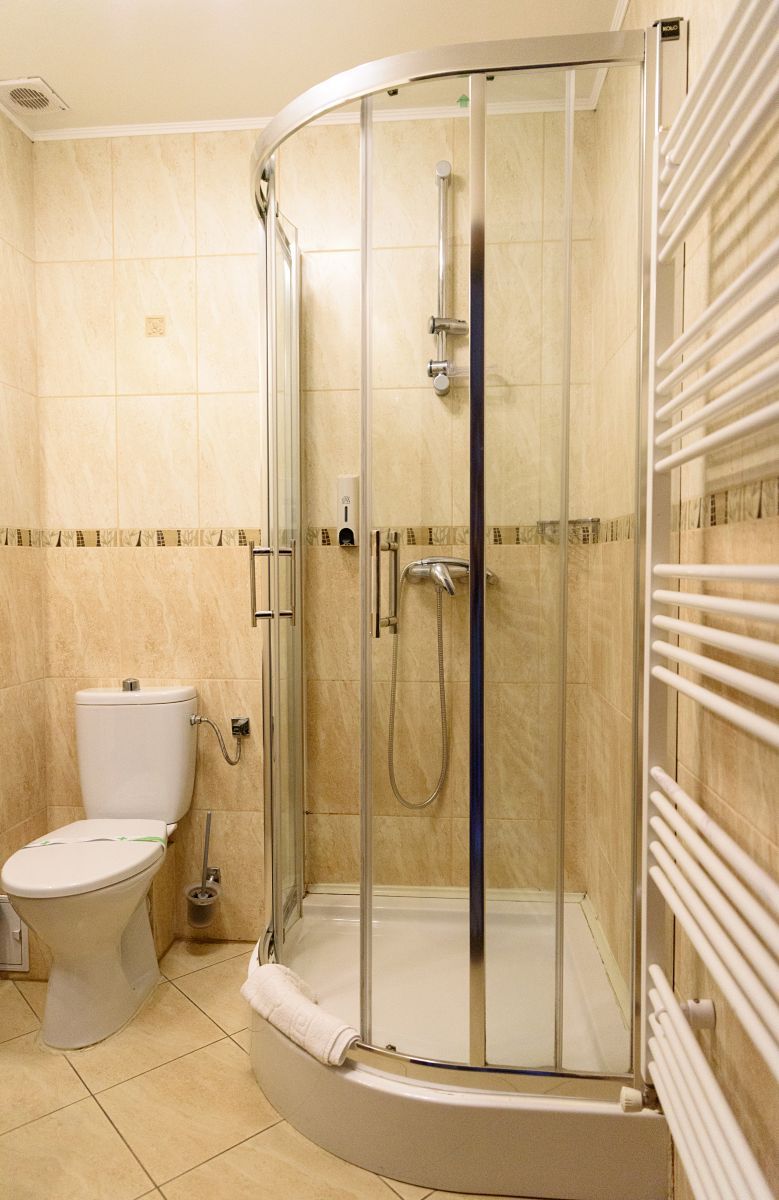Ein modernes Badezimmer mit Duschkabine, Toilette und Handtuchhalter.