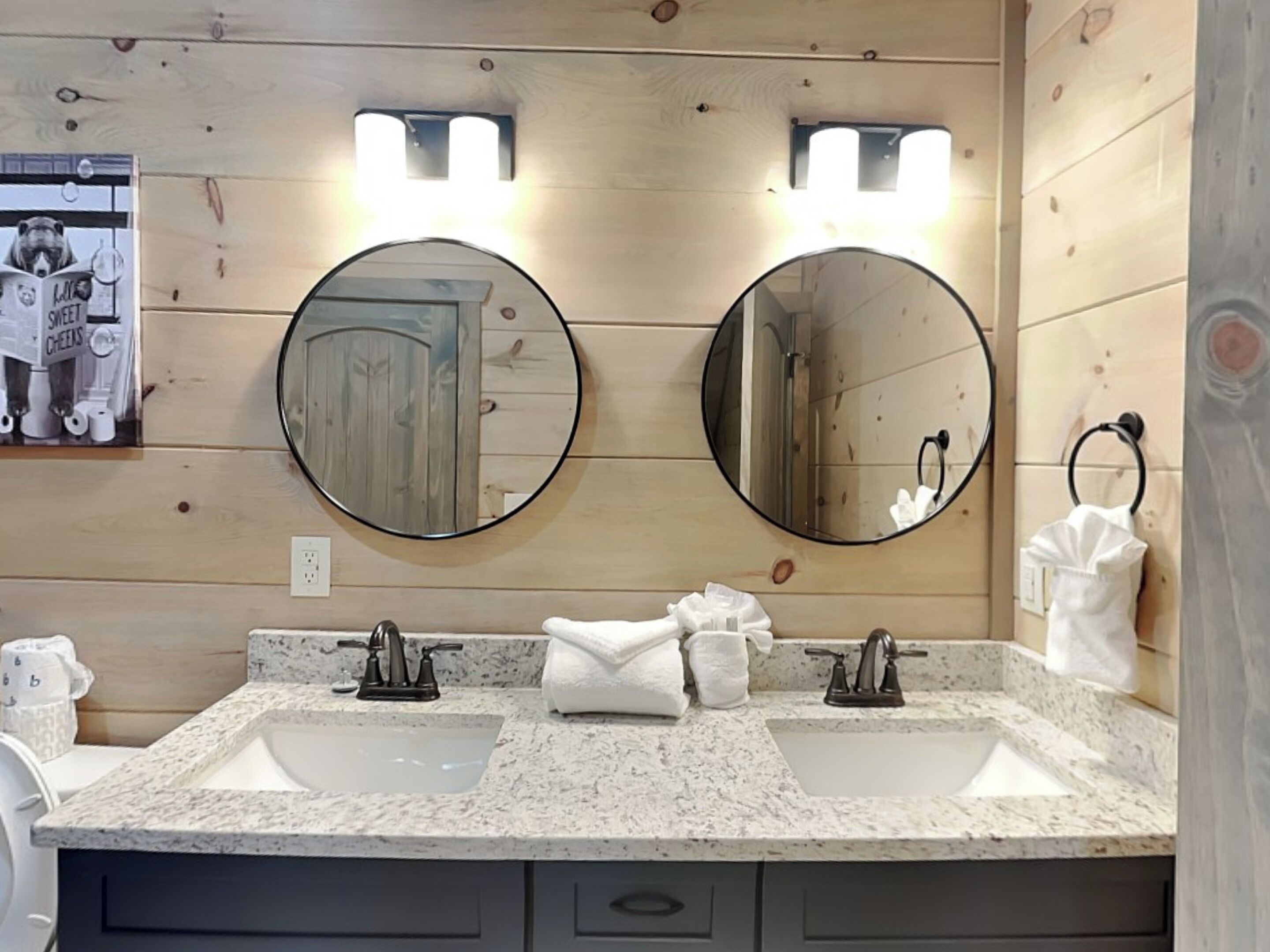 A bathroom with two sinks, a mirror, and a towel rack.