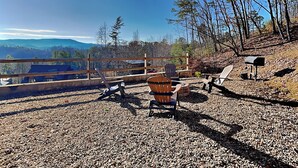 A gravel patio with outdoor furniture, a wooden fence, and a mailbox. - Breathless Views by Smoky Cove Resort (Sevierville)
