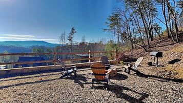 A gravel patio with outdoor furniture, a wooden fence, and a mailbox.