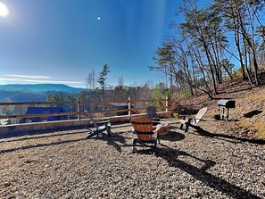 Une terrasse en gravier avec des meubles d’extérieur, une clôture en bois et une boîte aux lettres.