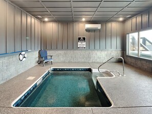 Ein Hallenbad mit Rettungsschwimmerstuhl und Warntafel.