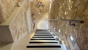 A modern staircase with stone walls and a metal handrail. - Window in the Stone Naples (Naples)