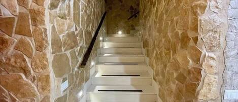 A staircase with white steps and stone walls.