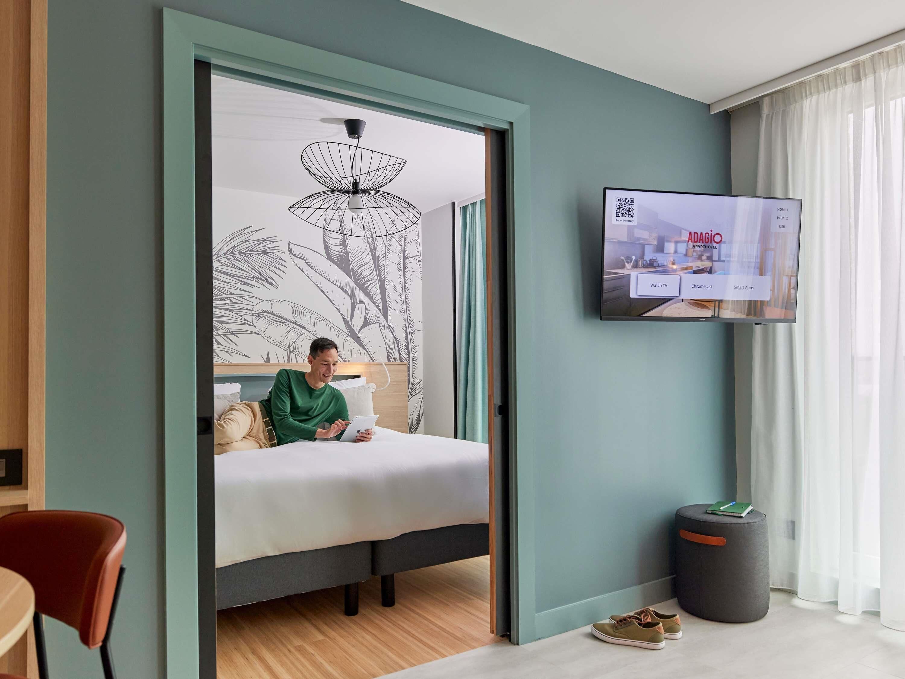 A hotel room with a bed, a television, a desk, and a chair.