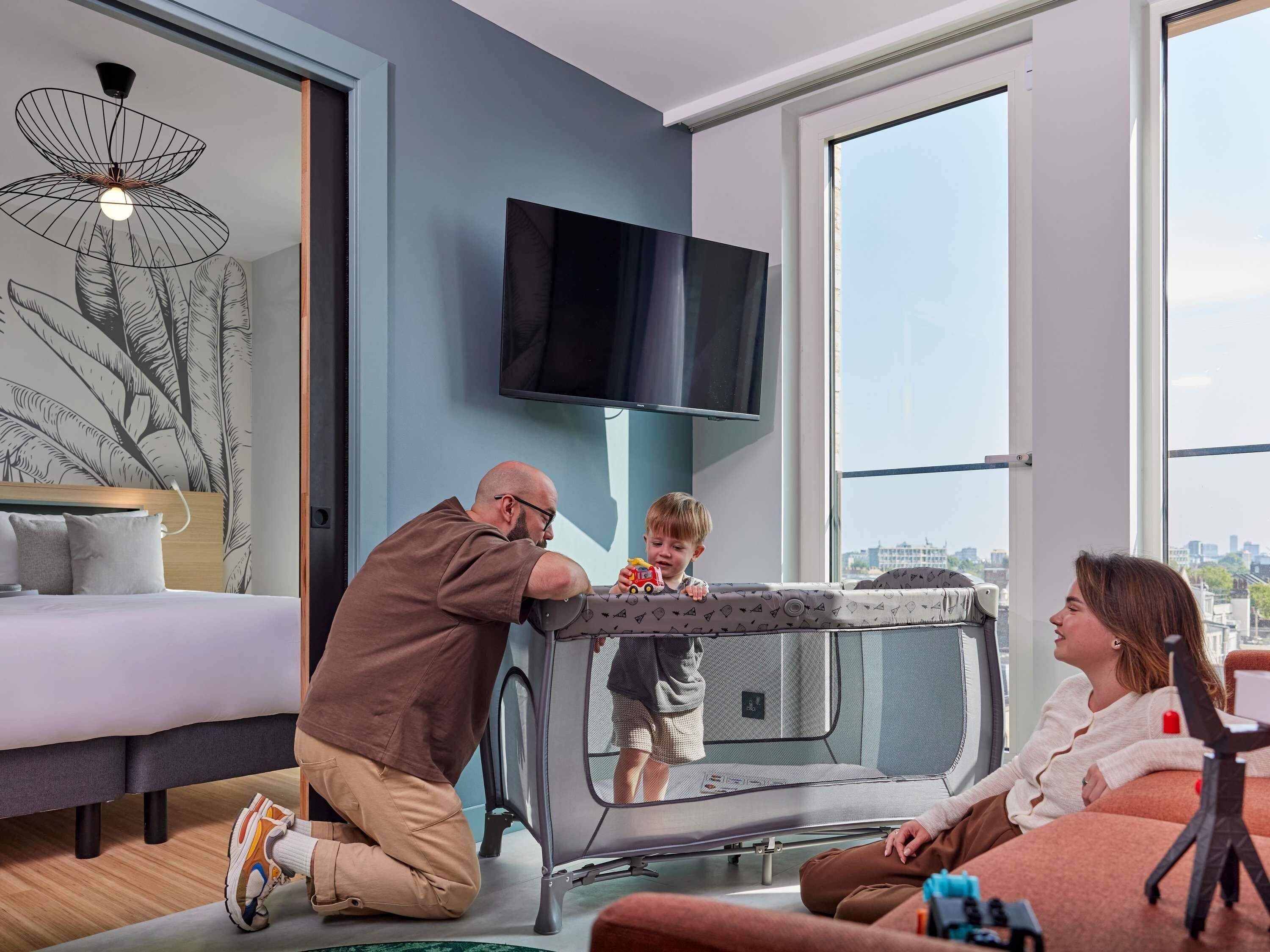 Ein modernes Wohnzimmer mit großem Fenster, Flachbildfernseher und einer Couch.