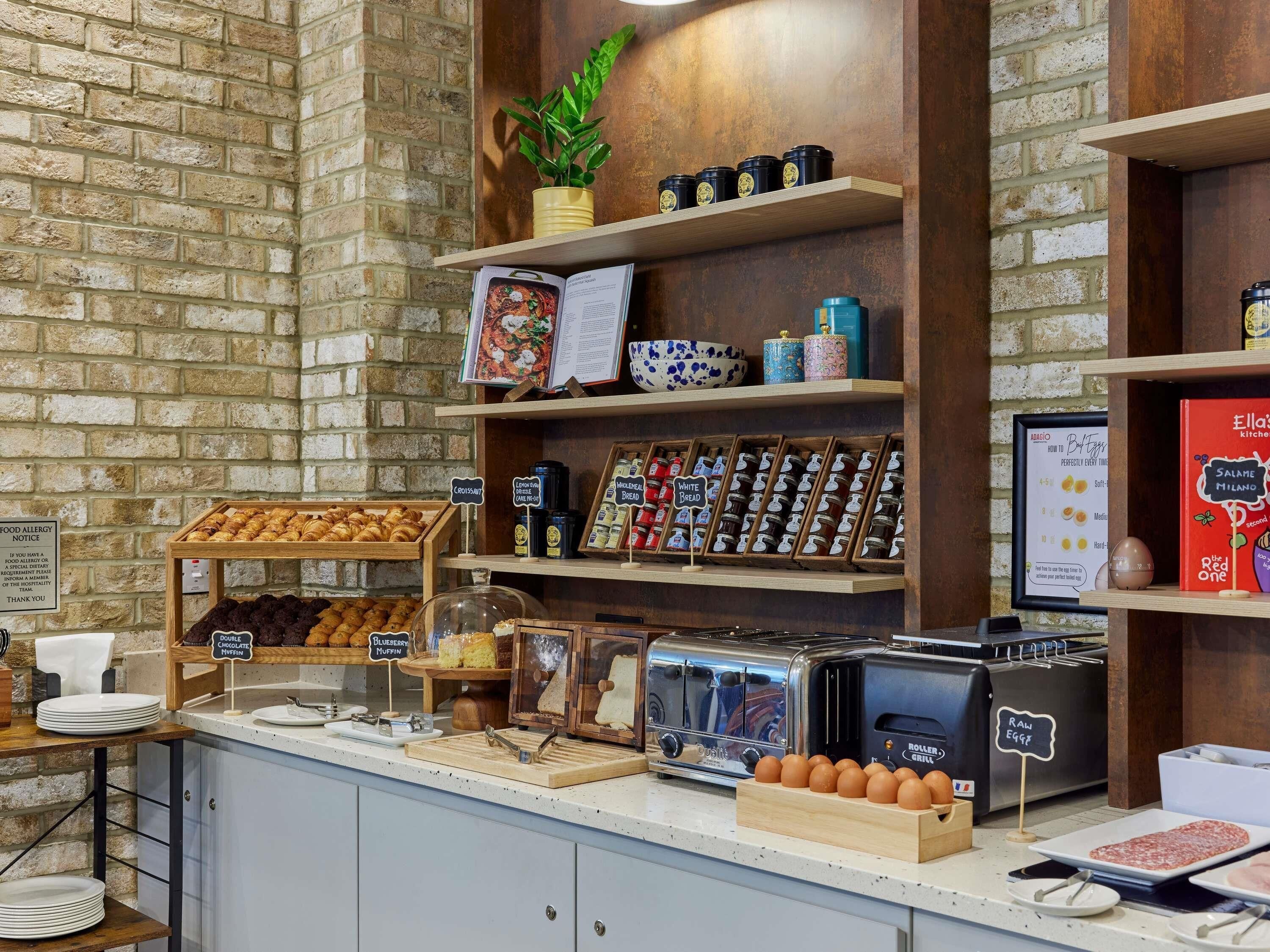 A bakery counter with various baked goods, a coffee machine, and a menu board.