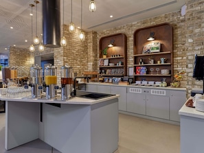 Un café con pared de ladrillo, una barra de café y diversos productos alimenticios en estantes.