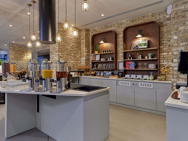 Un café con pared de ladrillo, una barra de café y diversos productos alimenticios en estantes.