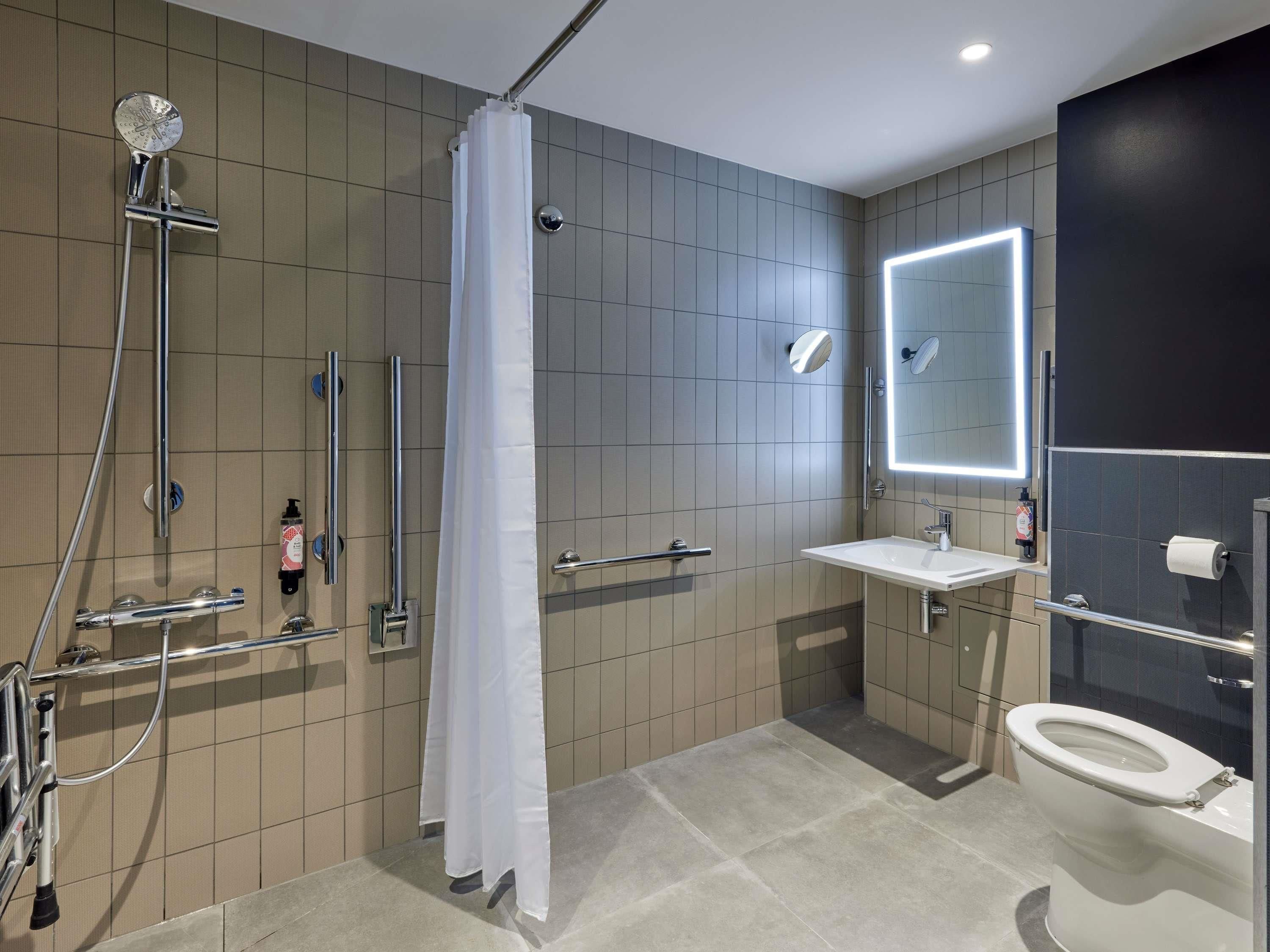 Un baño moderno con ducha, inodoro y lavamanos.
