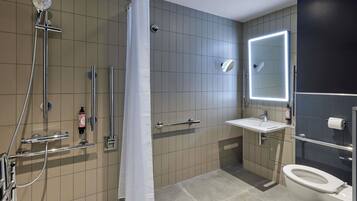 Un baño moderno con ducha, inodoro y lavamanos.