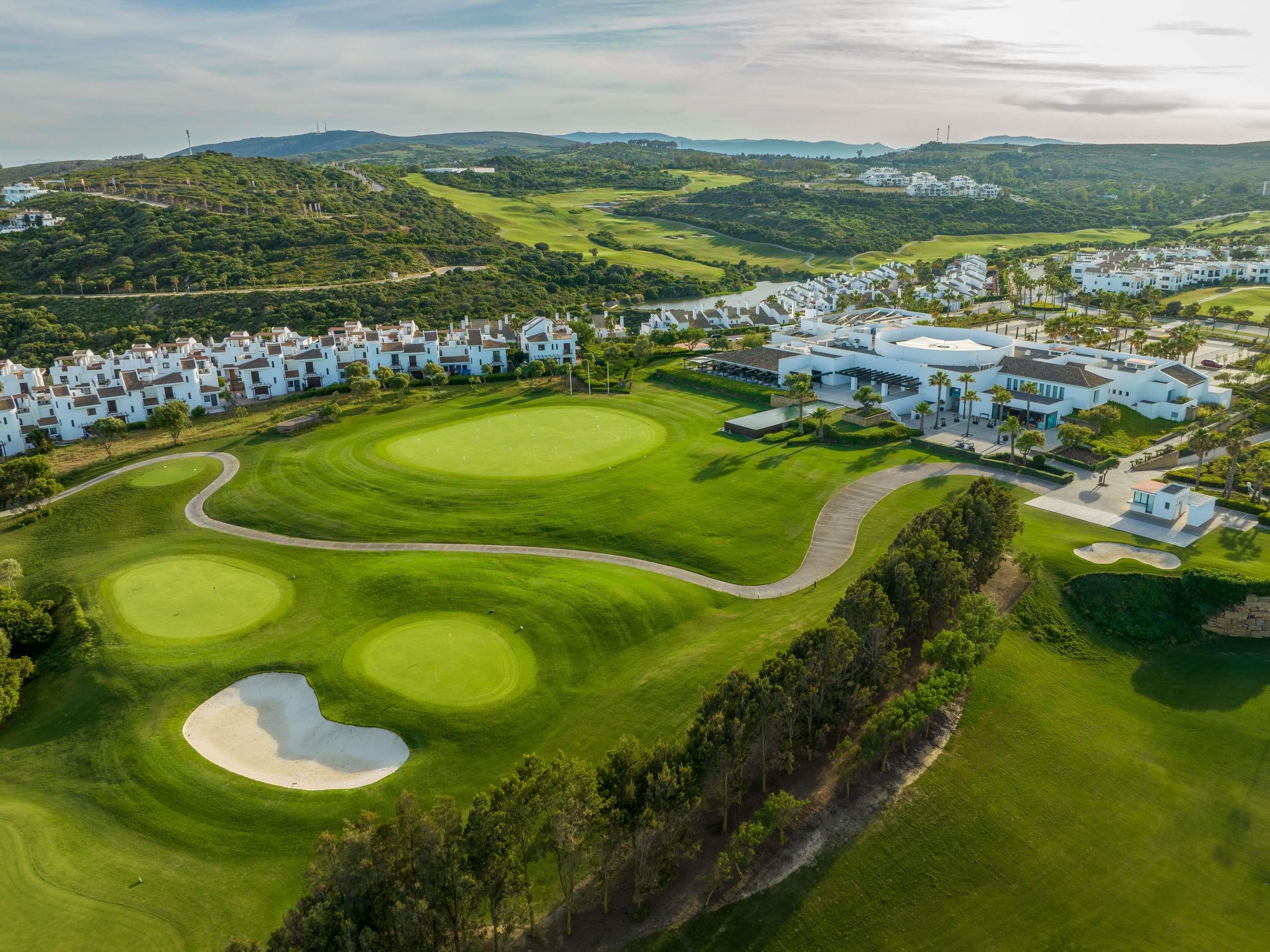 Un campo de golf con bunkers de arena y un club de campo.