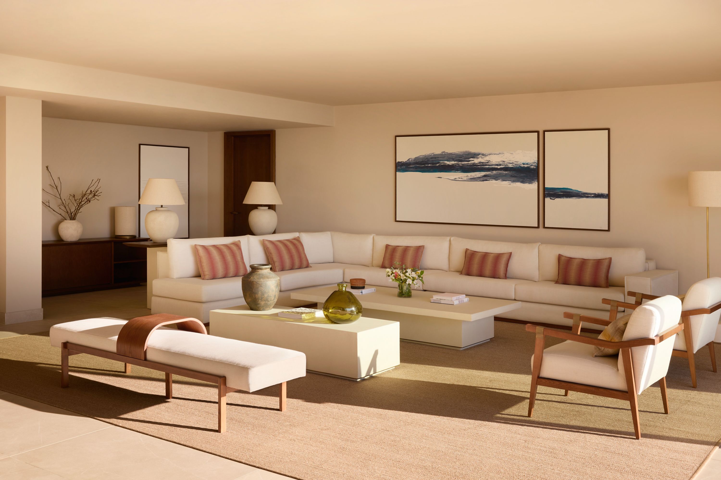A modern living room with a sectional sofa, a coffee table, and two armchairs.