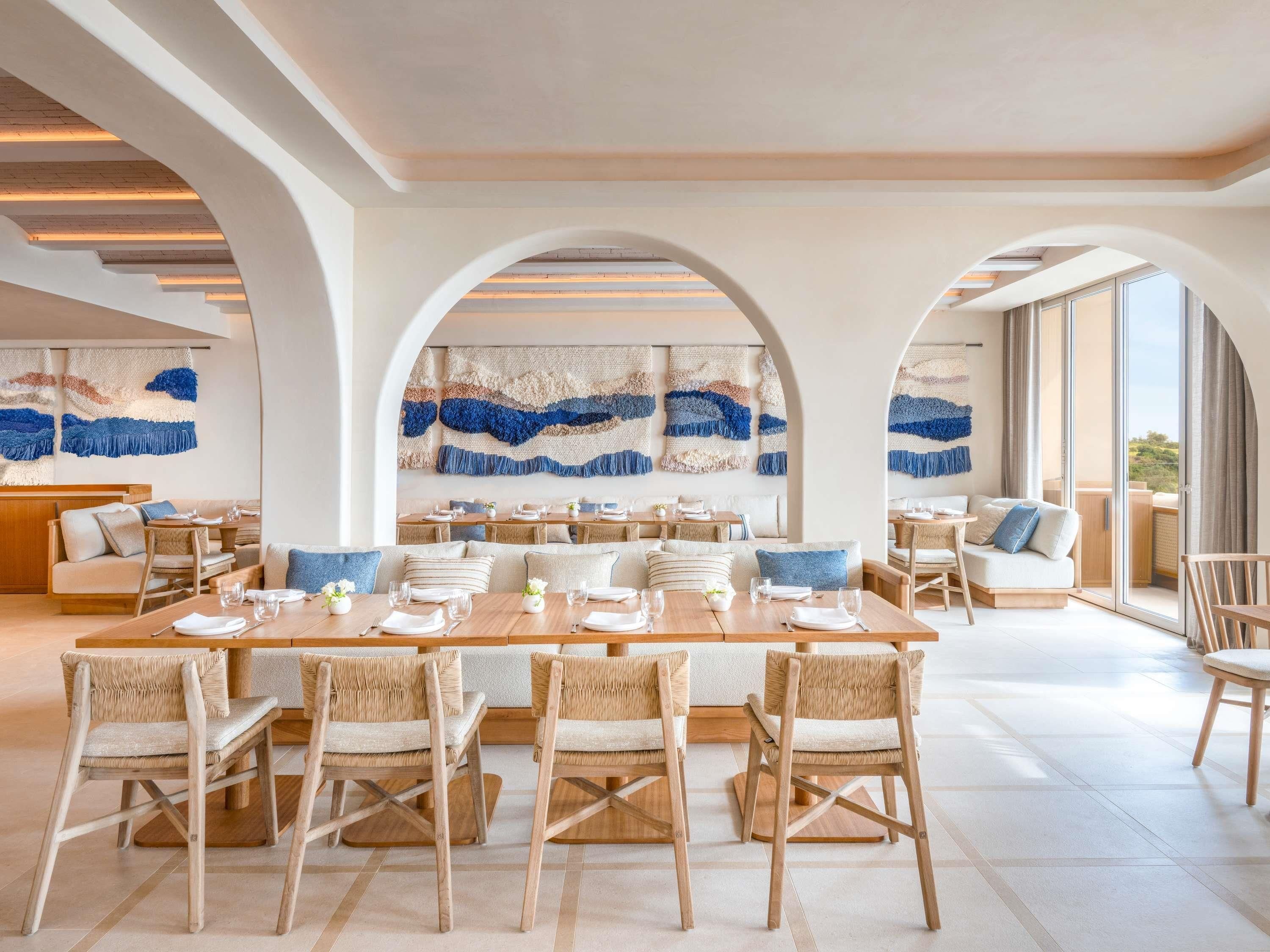Un comedor espacioso con techos altos, arcos y un gran ventanal que ofrece vistas al exterior.