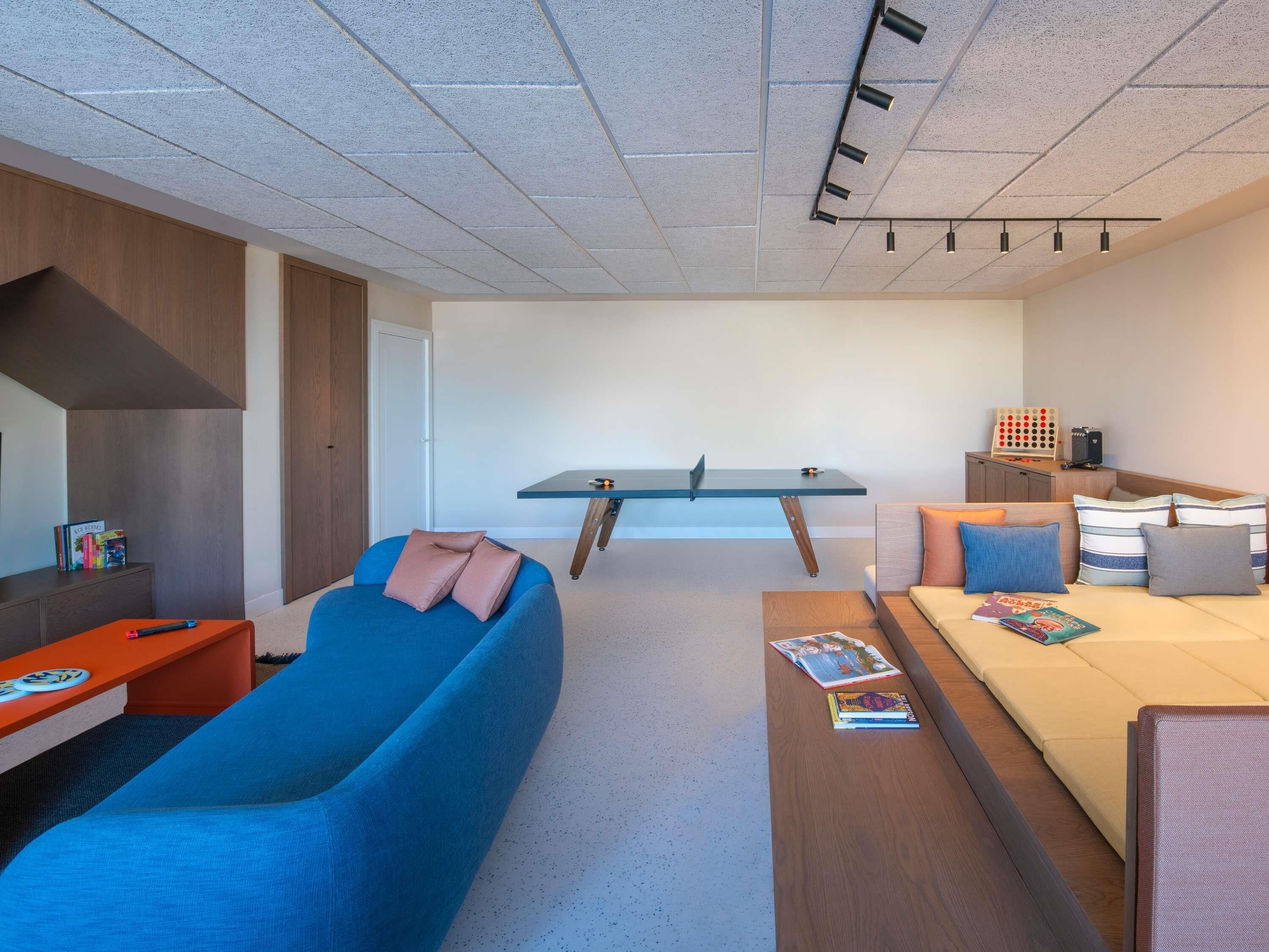 Una habitación moderna y minimalista con sofá, una mesita, escritorio y cama.