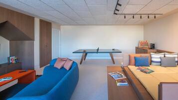 Una habitación moderna y minimalista con sofá, una mesita, escritorio y cama.